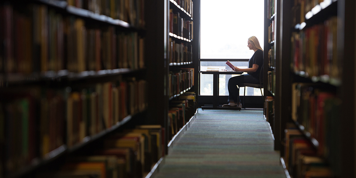 SIUE student sitting near a window in Lovejoy Library. 