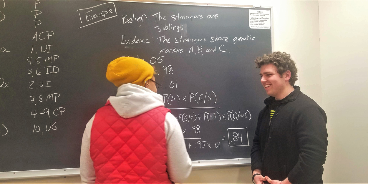 Two students working at a chalk board at SIUE.