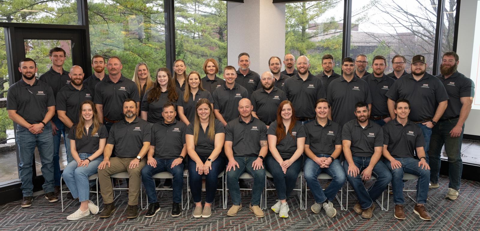 CLI Class of 2024 group photo in front of wall of windows