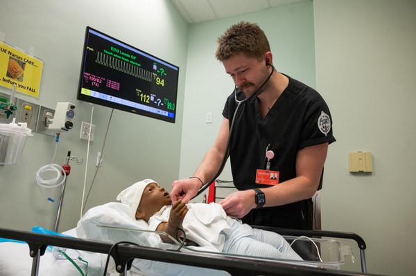 Male nurse simulates treatment of infant patient