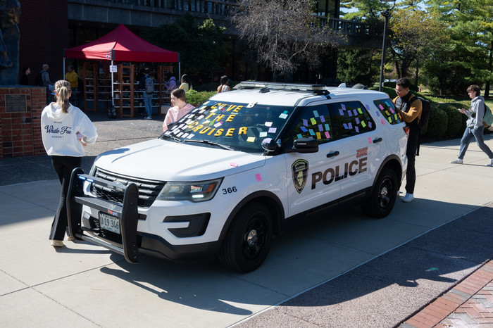 SIUE police SUV outside the cougar statue on a sunny fall day and covered with pastel sticky notes