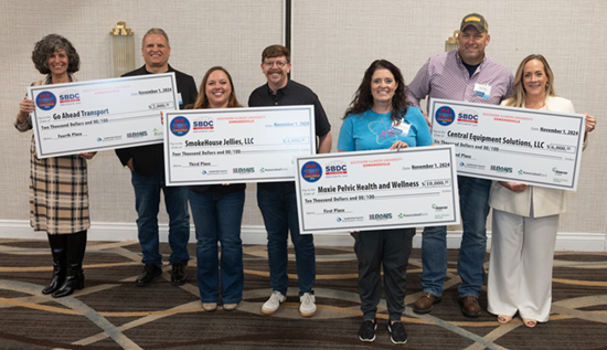 Group of people holding four large checks for photos